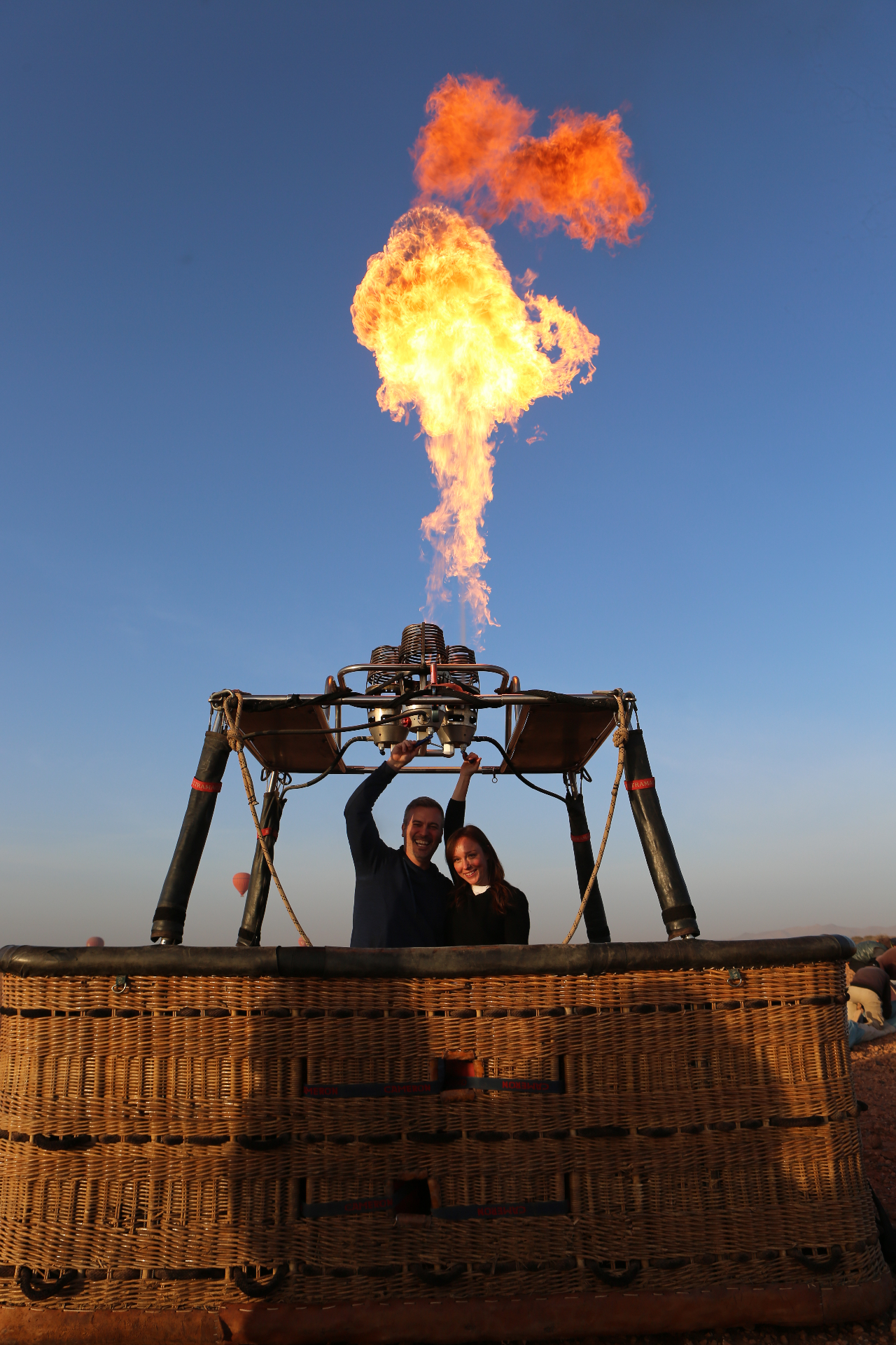 Couple lighting the burner beneath a bright flame