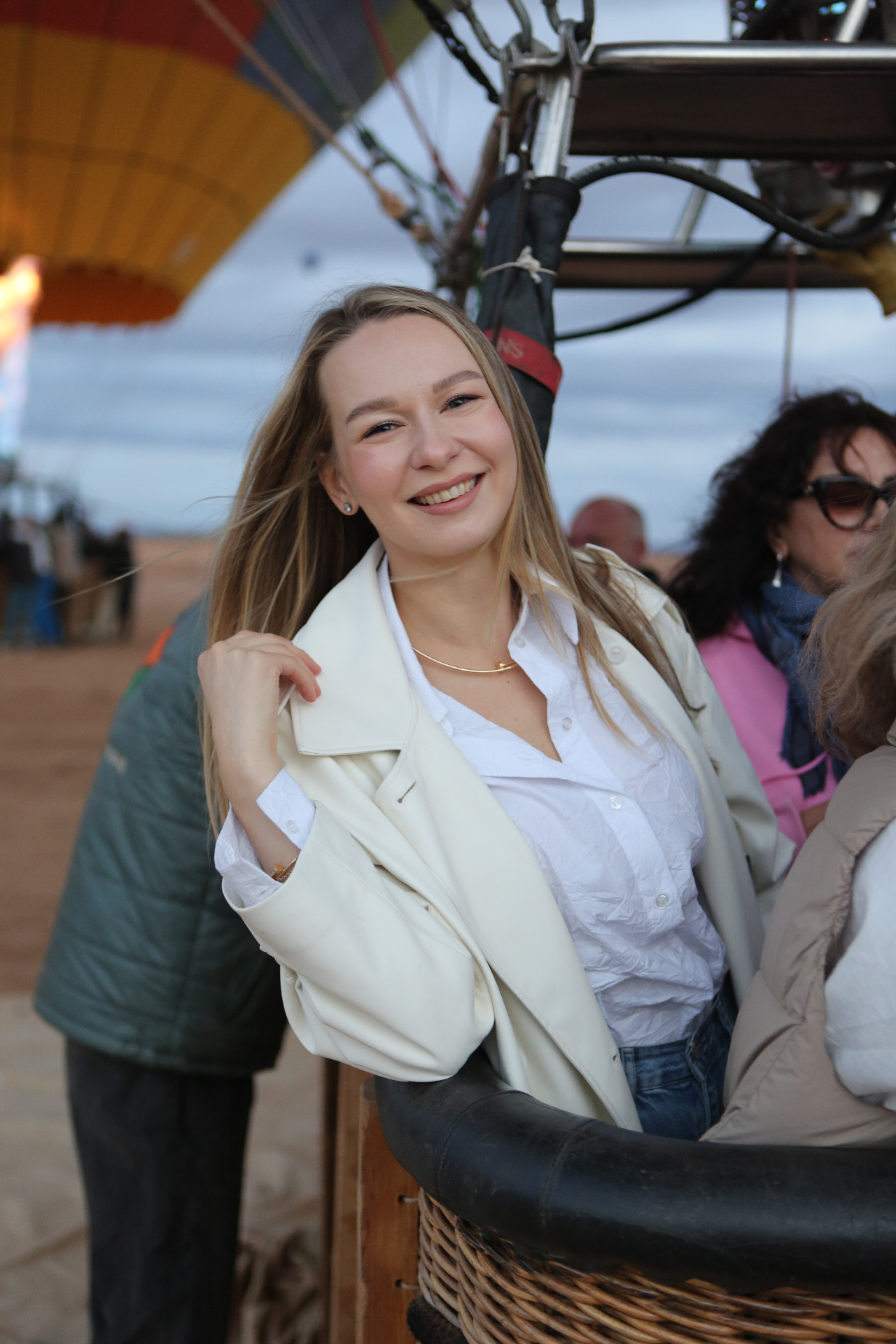 Guest smiling in the balloon basket at sunrise